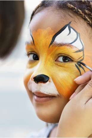 Professional face painting service creating artistic tiger design at corporate family event